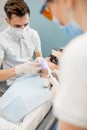 Male dentist and assistant using dental curing light Royalty Free Stock Photo