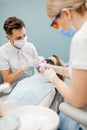 Male dentist and assistant using dental curing light Royalty Free Stock Photo