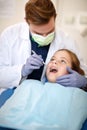 Dentist with dental mirror examining child`s teeth Royalty Free Stock Photo