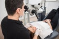 Male dentist with dental tools - microscope, mirror and probe checking up patient teeth at dental clinic office Royalty Free Stock Photo