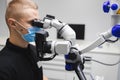 Male dentist doctor using microscope for dental treatment. Royalty Free Stock Photo