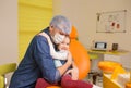 a male dentist hugs a little girl patient sitting in a dental chair Royalty Free Stock Photo