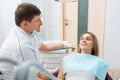 Male dentist and woman at dentaloffice. Patient and doctor during conversation