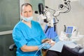 Male dentist working with microscope at modern dentist clinic