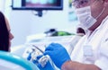 Male dentists examining and working on young female patient.Dentist`s office.