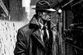 male detective investigator hat and coat on rainy street at night. Cartoon Noir comics style Royalty Free Stock Photo