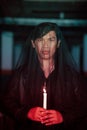 a male devil worshiper with a transparent veil is performing a spooky ritual by holding a candle in his hand Royalty Free Stock Photo