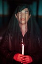 a male devil worshiper with a transparent veil is performing a spooky ritual by holding a candle in his hand Royalty Free Stock Photo