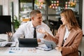 Male discussing new project with male colleague. Mature woman talking with young man in office Royalty Free Stock Photo