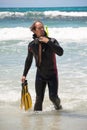 Male diver with diving suit snorkel mask fins on the beach Royalty Free Stock Photo