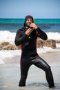 Male diver with diving suit snorkel mask fins on the beach