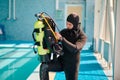 Male diver puts on oxygen tank, diving school