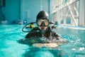 Male diver in scuba gear and mask poses in pool