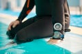 Male diver in scuba gear sitting at the poolside
