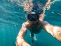 Male diver swims in the sea under the blue water with a mask and snorkel Royalty Free Stock Photo