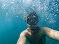 Male diver swims in the sea under water with a mask and snorkel is taking a selfie of your face Royalty Free Stock Photo