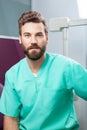 Male doctor with beard in green costume in dental clinic Royalty Free Stock Photo