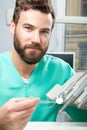 Male doctor with beard in green costume in dental clinic Royalty Free Stock Photo