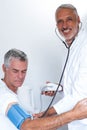 Male doctor checking senior mans blood pressure Royalty Free Stock Photo