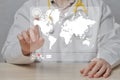 A male doctor in a coat looks through messages, calls, mail from around the world on a map on an abstract display Royalty Free Stock Photo