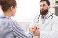 Male doctor comforting patient at consulting room Royalty Free Stock Photo