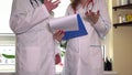 Male doctor consulting female colleague with folder in hands