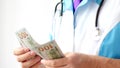 Male doctor counting dollars close-up. Corruption in medicine. Royalty Free Stock Photo