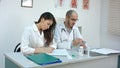 Male doctor counting money and giving it to his female partner Royalty Free Stock Photo