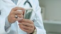 Male doctor counting money and putting it in his pocket Royalty Free Stock Photo