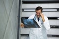 Male doctor discussing x-ray on mobile phone while walking downstairs Royalty Free Stock Photo