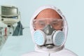 Male doctor, disinfector in a protective suit, respirator, glasses on the background of a ventilator, the concept of biological,