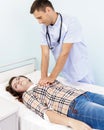 Male doctor doing cardiac massage young woman patient in hospital office