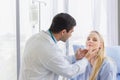 Male doctor examined the neck pain of a female patient sitting in hospital Royalty Free Stock Photo