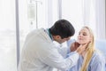 Male doctor examined the neck pain of a female patient sitting in hospital