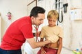 Male Doctor Examining Boy. Pediatrician examining boy patient with stethoscope. Royalty Free Stock Photo