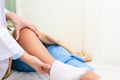 Male doctor examining the knees of an obese patient lying on a nursing bed. Royalty Free Stock Photo