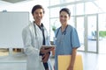 Male doctor and female nurse looking at camera in the lobby of hospital Royalty Free Stock Photo