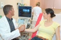 Male doctor with female patient undergoing arm echography