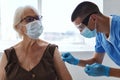 male doctor giving an injection to an elderly woman vaccination covid passport immunity protection Royalty Free Stock Photo