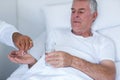 Male doctor giving pill to senior man Royalty Free Stock Photo