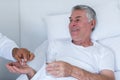 Male doctor giving pill to senior man Royalty Free Stock Photo