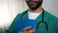 Male doctor going to fill in history of patients disease, hospital checklist