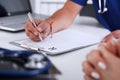 Male doctor hand write prescription at office worktable