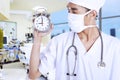 A male doctor holding an alarm clock