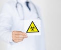 Male doctor holding boihazard caution sign Royalty Free Stock Photo