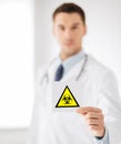 Male doctor holding boihazard caution sign Royalty Free Stock Photo