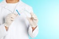 Male doctor holding disposable speculum on color background, closeup with space for text.