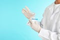 Male doctor holding disposable speculum on color background, closeup with space for text.