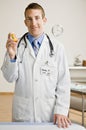 Male doctor holding out medication bottle Royalty Free Stock Photo