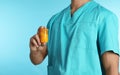 Male doctor holding pill bottle on color background. Medical object Royalty Free Stock Photo